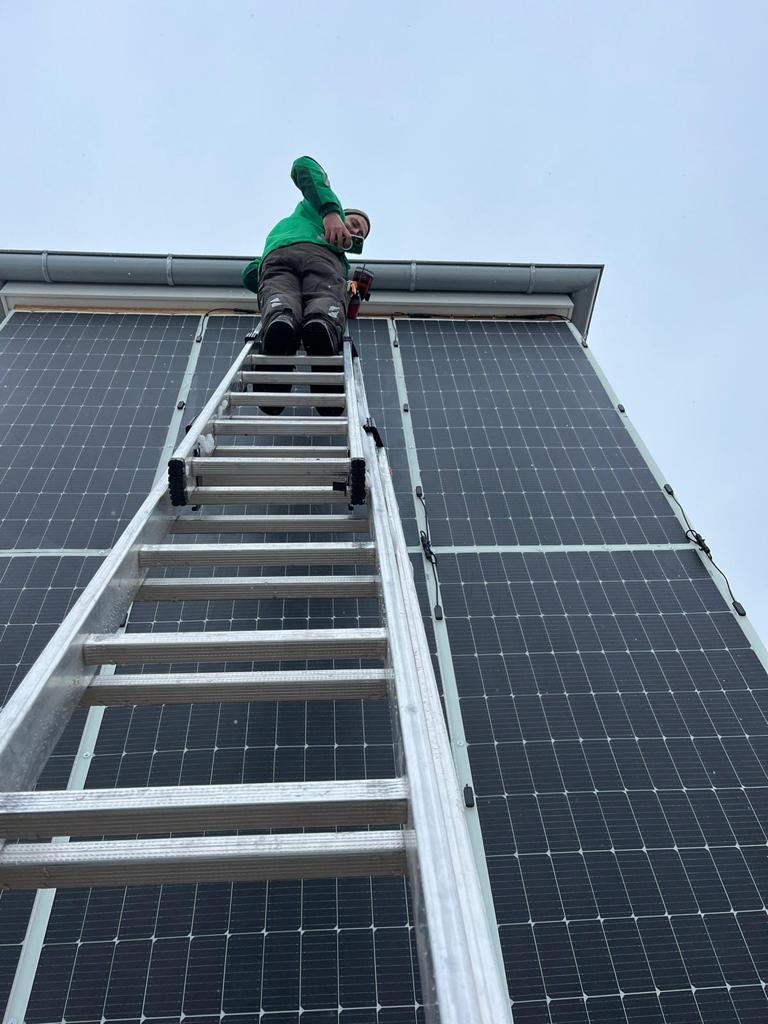Ein engagierter Mitarbeiter des WerdGrün-Teams bei der professionellen Installation einer Solaranlage mit Speicher, um nachhaltige Energie zu gewinnen.