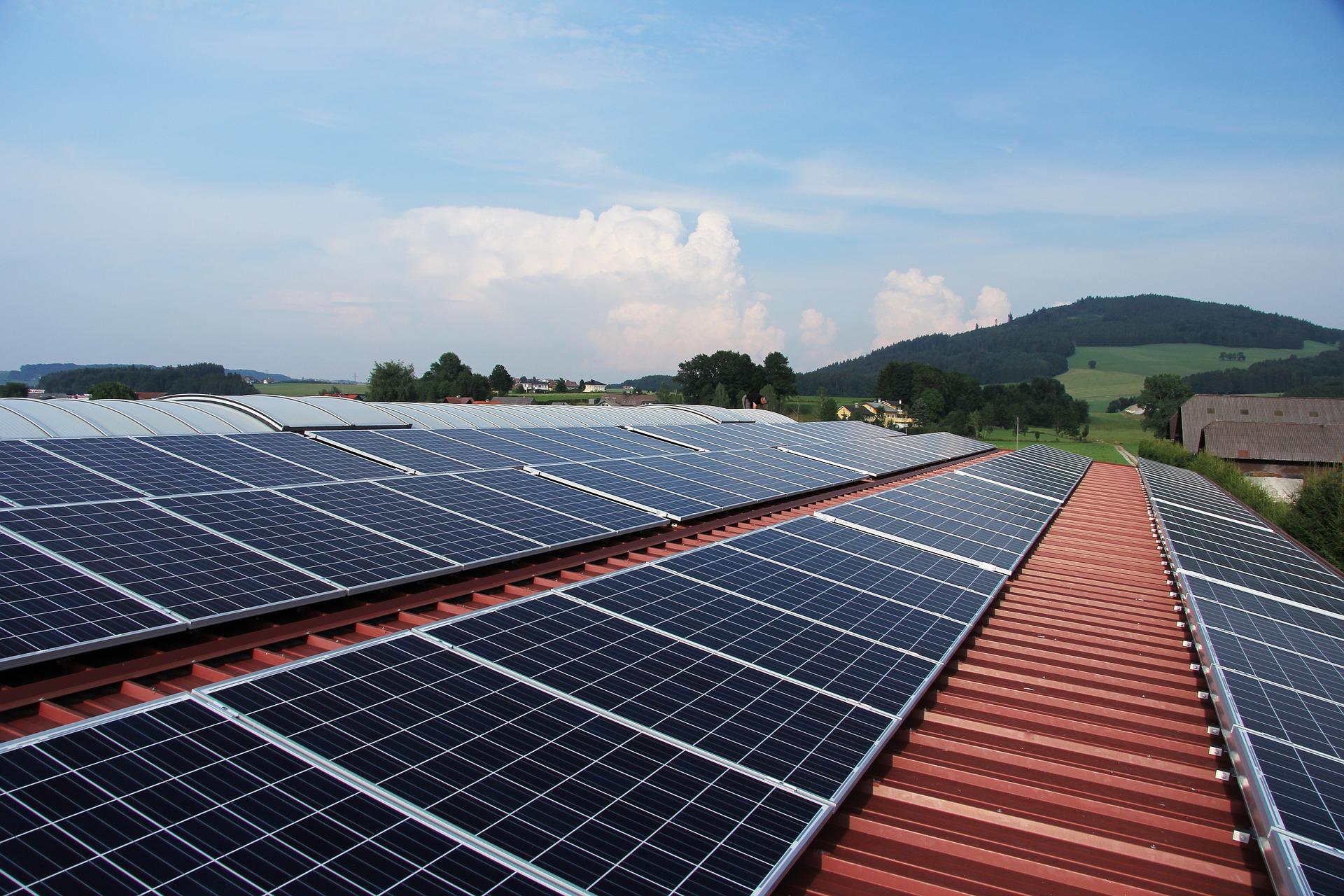 Photovoltaik Speicher: Solarmodule auf einem Dach in einer grünen Landschaft, ideal für nachhaltige Energieerzeugung und Stromspeicherung.