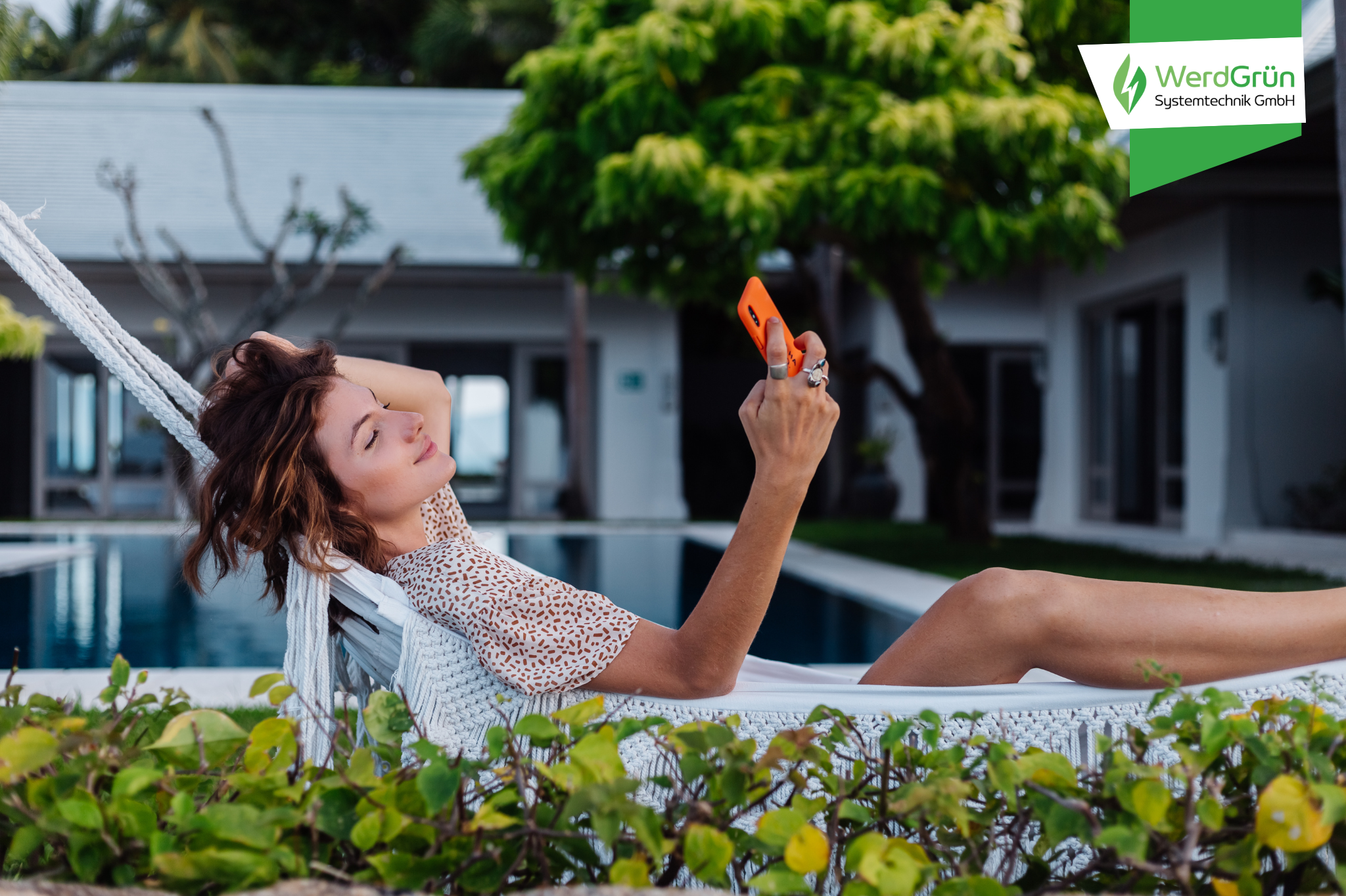 Frau auf einer Liege im Sommer guckt auf ihr Handy