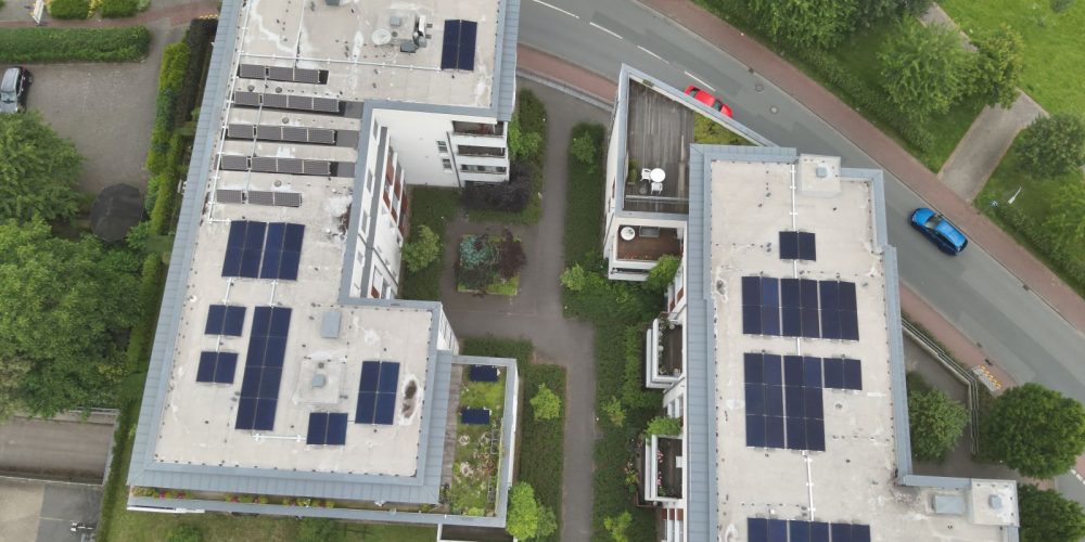 Luftaufnahme von zwei Mehrfamilienhäusern mit installierter 25kWp Photovoltaikanlage für ein Mieterstrommodell, umgesetzt von WerdGrün Systemtechnik GmbH.