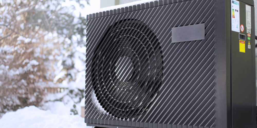 Wärmepumpe für Zuhause im Außenbereich, installiert auf schneebedecktem Boden, für zuverlässigen Betrieb bei winterlichen Temperaturen.